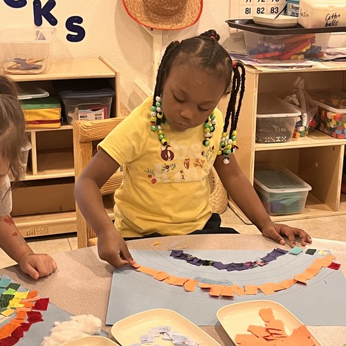 Girl creating a mosaic art project at a Christian daycare center in Las Vegas during arts and crafts time.