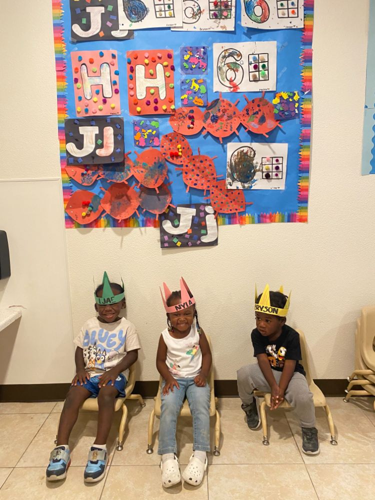 Children wearing birthday crowns in front of a decorated classroom wall at a Christian daycare in Las Vegas.