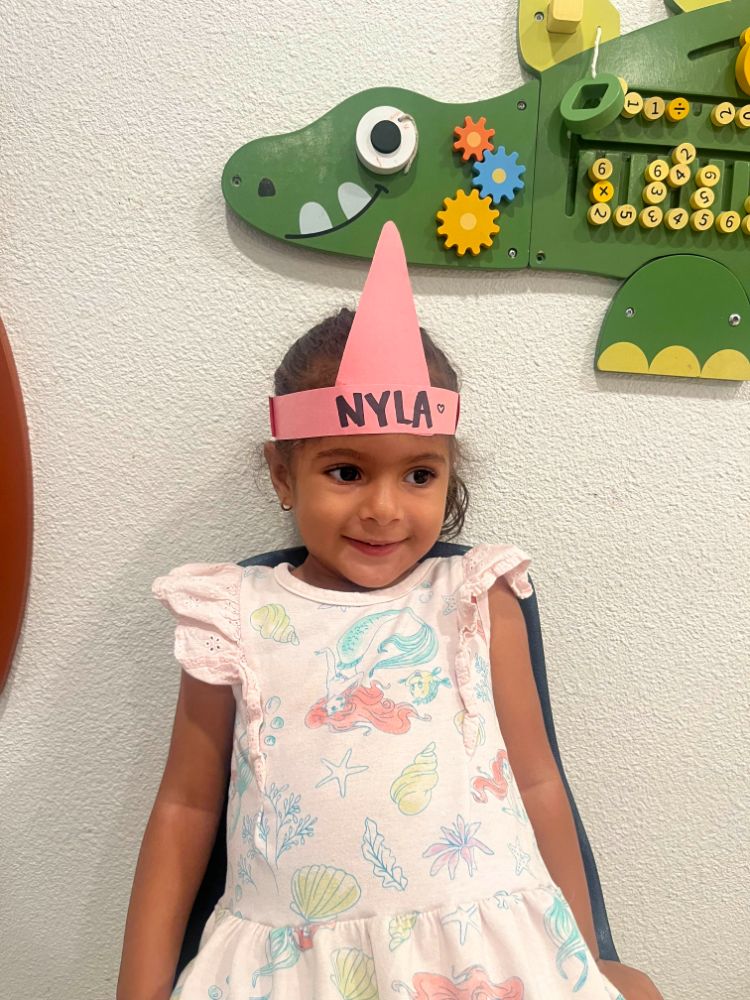 Smiling girl named Nyla with a handmade crown at a Christian childcare center in Las Vegas.