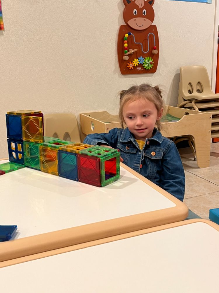 Young girl at Christian daycare center in Las Vegas building with colorful magnetic tiles.