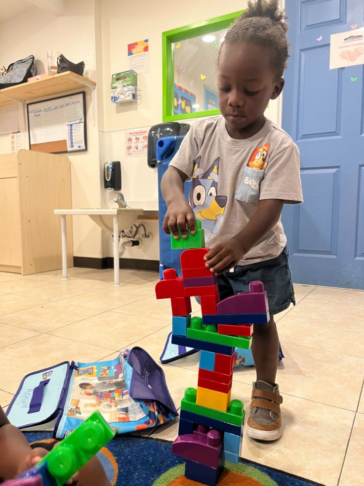 Boy at Christian childcare in Las Vegas stacking large interlocking building blocks.