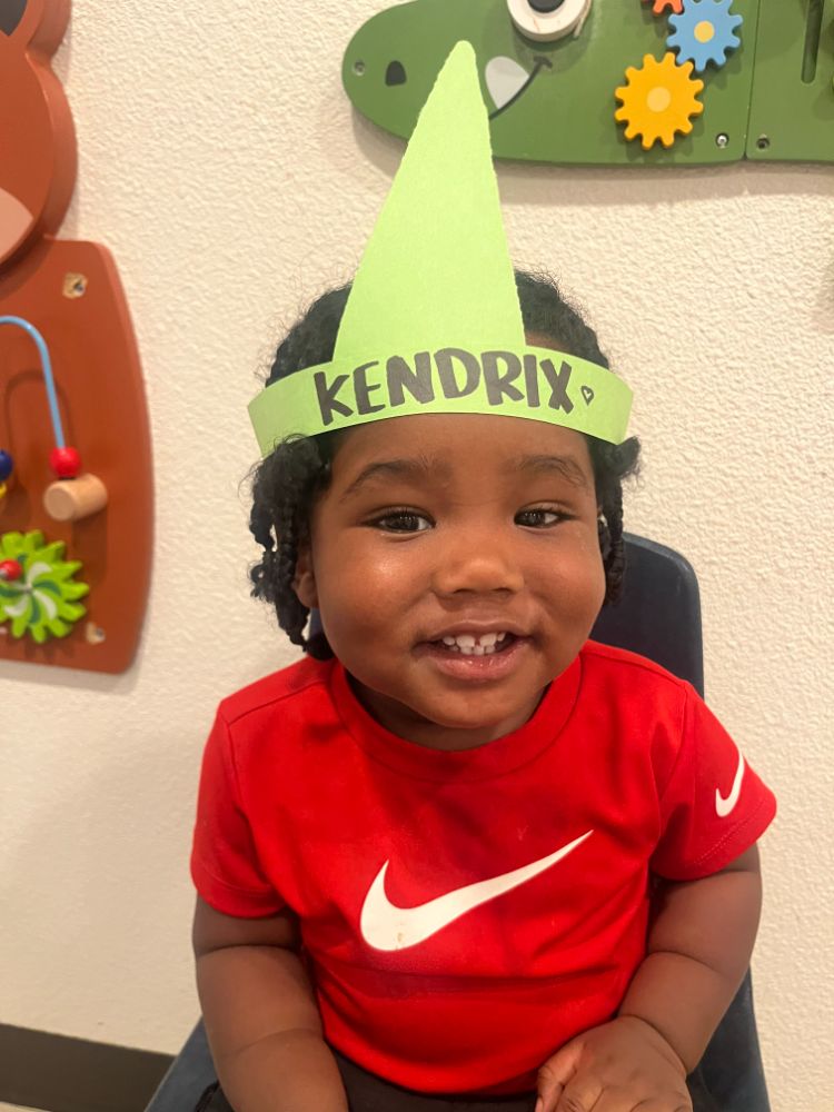 Smiling boy named Kendrix with a green handmade crown at a Christian daycare center in Las Vegas.