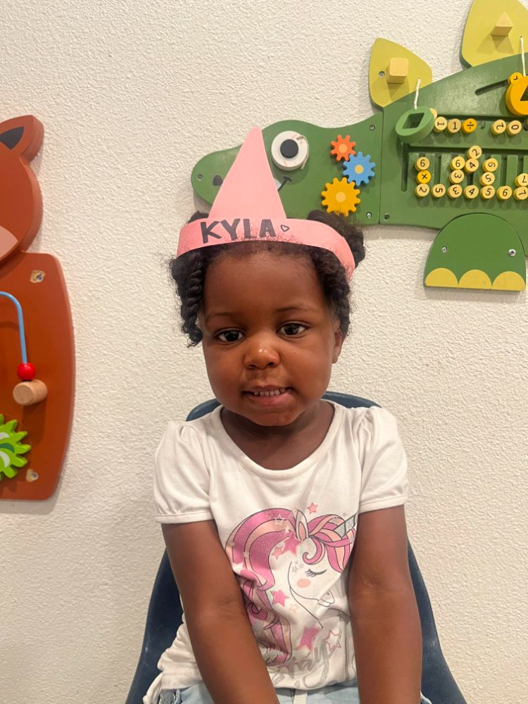 Two-year-old girl smiling during an educational toddler class at a two-year preschool program in Las Vegas.